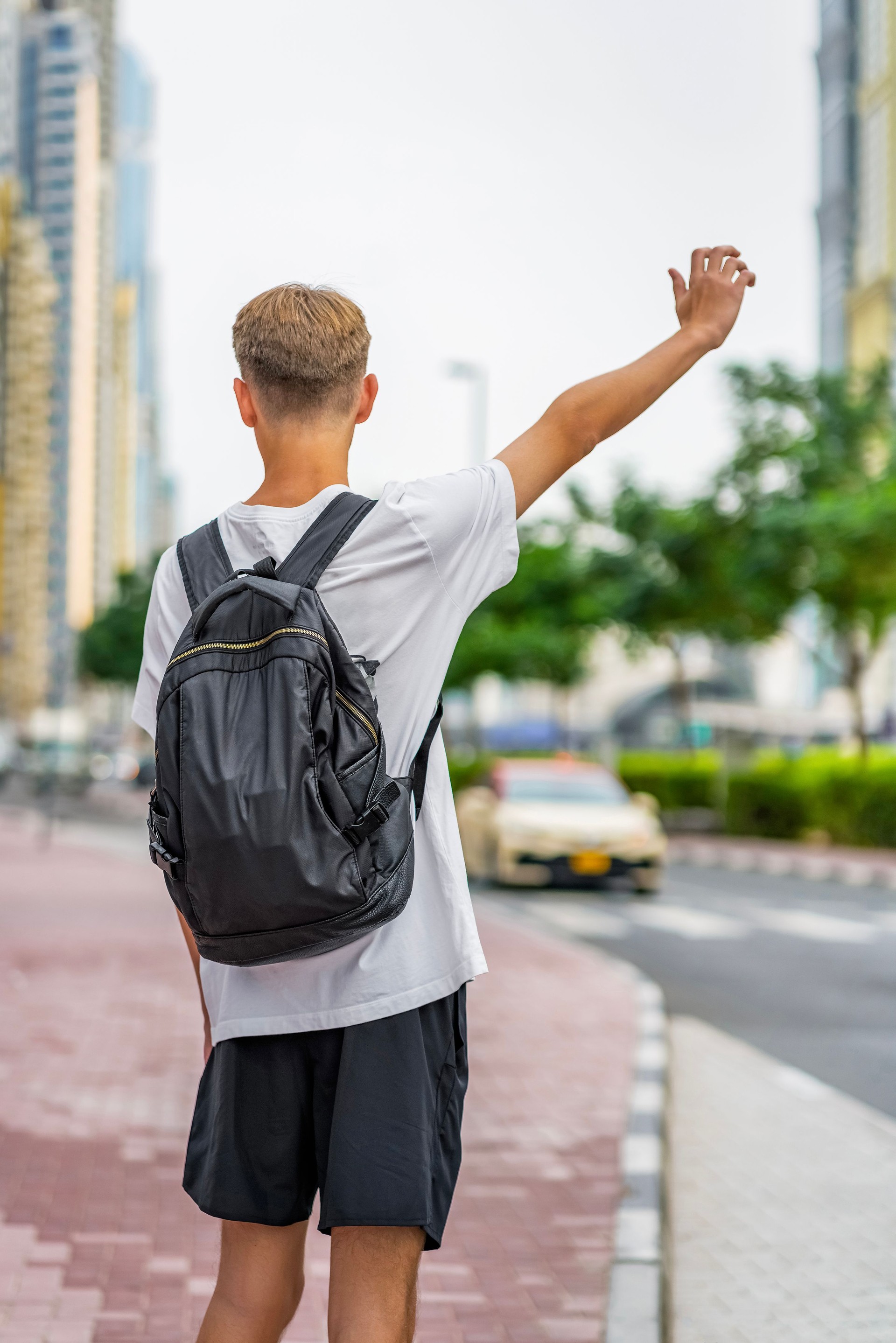 High school student, teenager with school bag on the way to school or walking home from school. student catch taxicar or school bus. Transport car. Get a ride